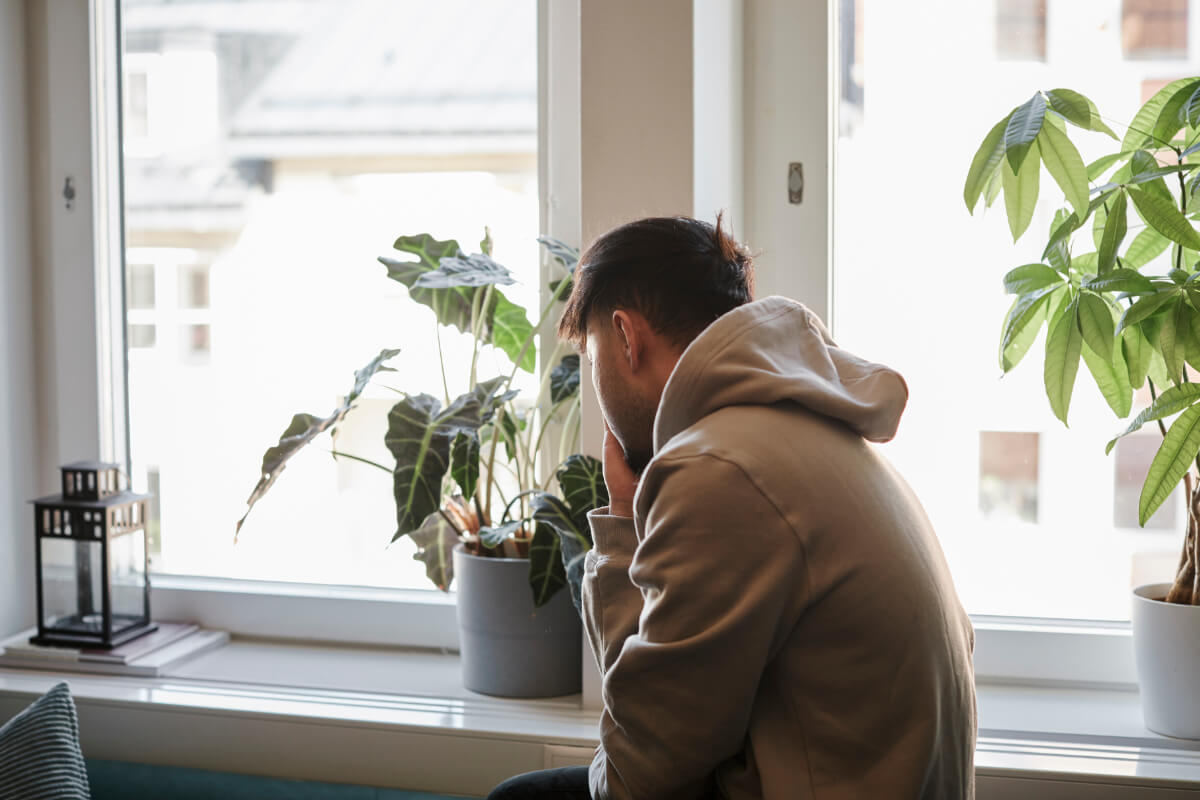 Ein Mann sitzt gebeugt in der Küche